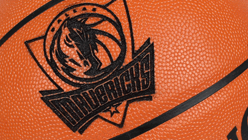 A basketball with the Dallas Mavericks logo, featuring a stylized horse head and the word 'MAVERICKS