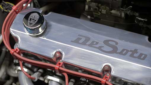 A polished metal engine component with the name 'De Soto' engraved on it