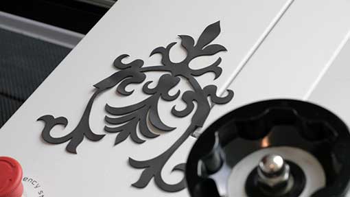 A decorative, black, ornate design affixed to a white surface