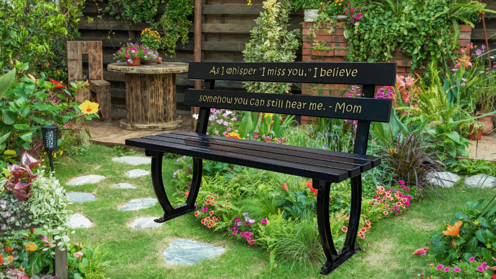 Engraved black garden bench in a vibrant flower garden, with a heartfelt memorial message from a mother.